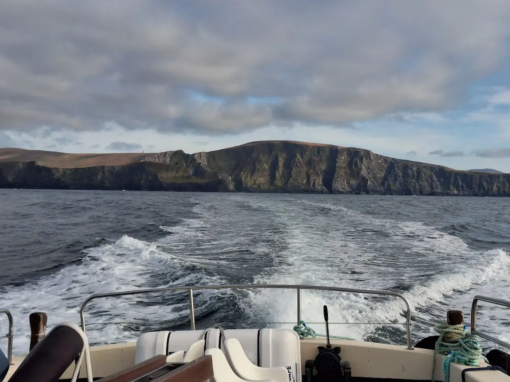 Boat view of rugged coastal Kerry cliffs on the way to Skellig Michael