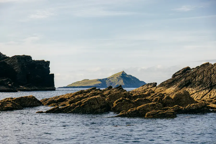 Puffin Island on the Skellig Michael Tour route - Rocky coastline with distant island view