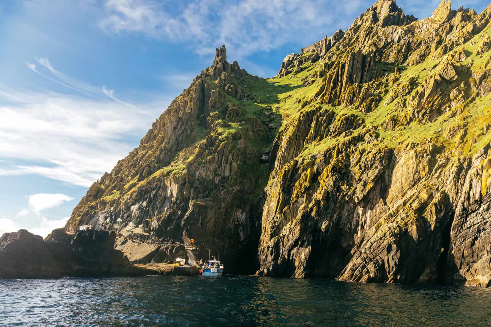 Boat approaches Skellig Michael's rocky coast; stone steps visible. Book Skellig Michael boat tours for an unforgettable experience.