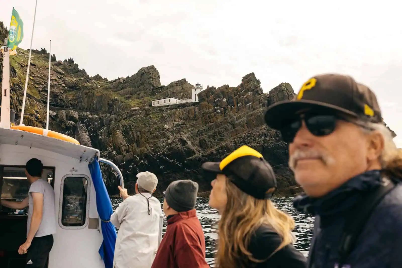 Tour boat beside Skellig Michael’s lighthouse road, showing the scale of this maritime heritage coastline.